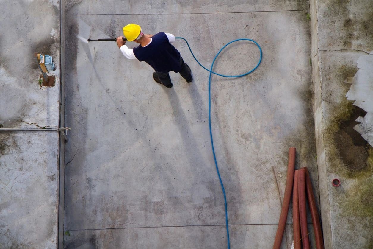 A man in yellow hard hat holding a hose.