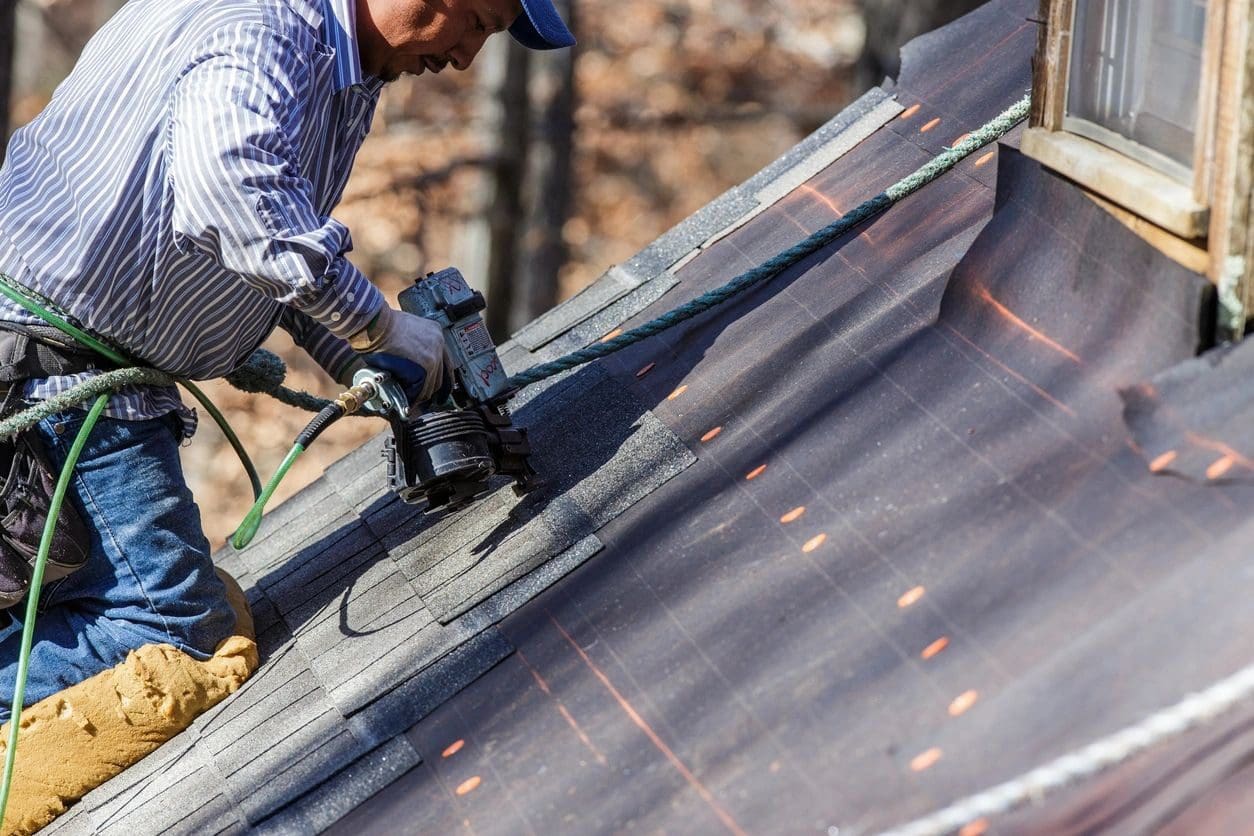 A man working on the roof of his home.